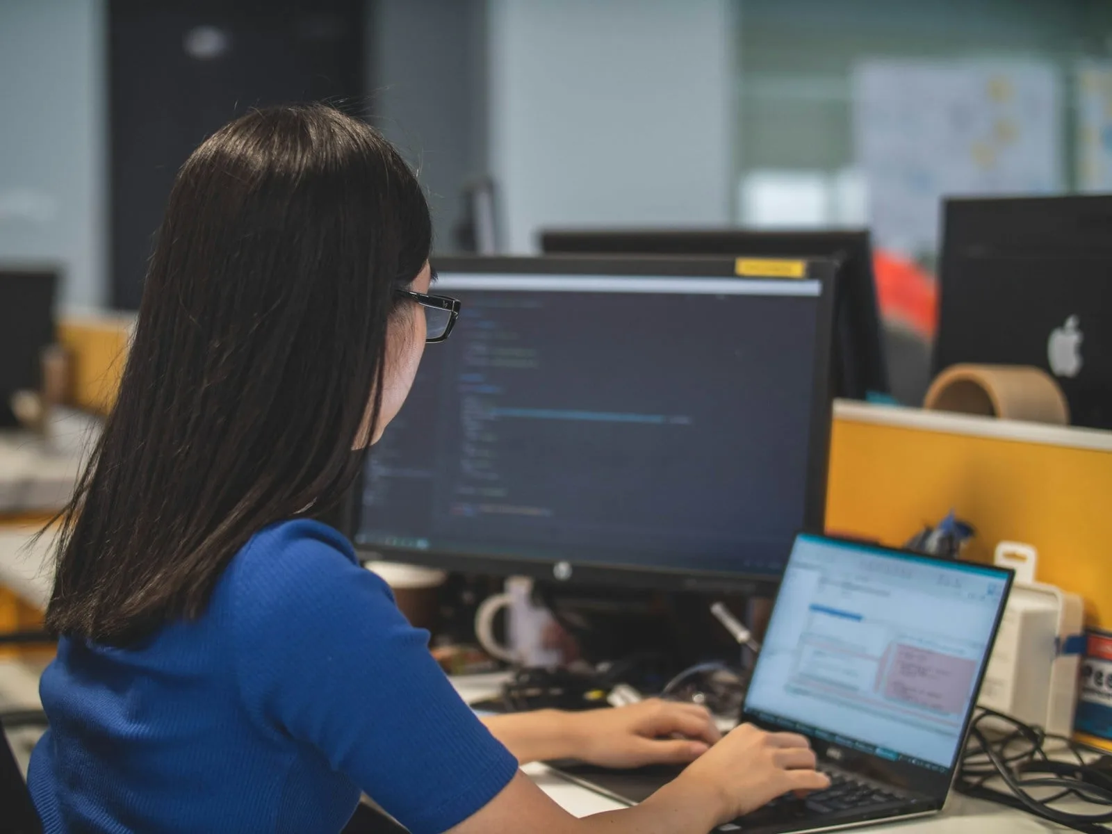 Asian IT professional at a workstation supporting Microsoft 365 customers in Singapore