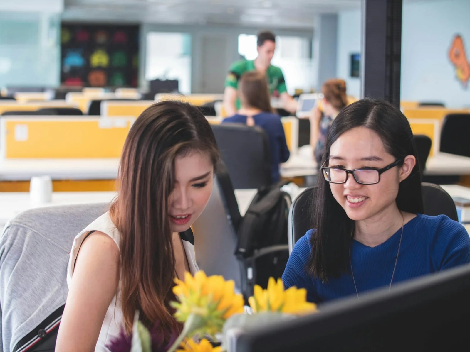 Asian colleagues reviewing Microsoft 365 security settings in Singapore